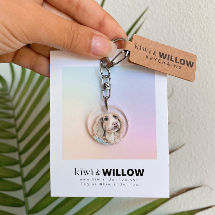 Keychain with a dog's face on a card held by a hand, with 'kiwi & Willow' branding.